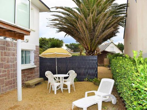 a patio with a table and chairs and an umbrella at Appartement rénové 3* avec jardin et WIFI à 20m de la plage - Trégastel - FR-1-368-77 in Trégastel