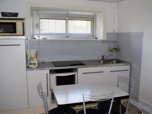 a small kitchen with a table and a sink at Appartement Trégastel, 2 pièces, 4 personnes - FR-1-368-77 in Trégastel