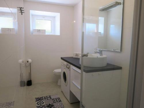 a bathroom with a sink and a washing machine at Appartement Trégastel, 2 pièces, 4 personnes - FR-1-368-77 in Trégastel