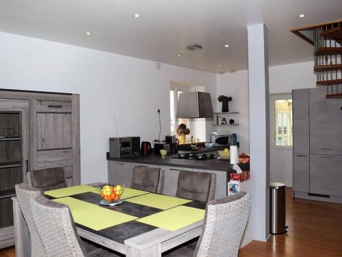 une cuisine avec une table et des chaises dans une cuisine dans l'établissement Maison en pierre 3* rénovée, jardin, WIFI, proche plage et commerces, Ploumanac'h - FR-1-368-87, à Perros-Guirec