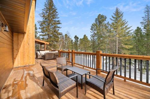 Un patio con sillas y una mesa en una terraza. en Trax N Trailz Lodge, en Lead