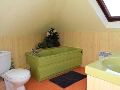 La salle de bains est pourvue d'une baignoire verte et de toilettes. dans l'établissement Appartement 3 chambres sur la plage à Perros-Guirec - FR-1-368-138, à Perros-Guirec