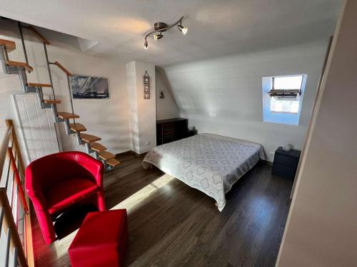 une chambre avec un lit et une chaise rouge dans l'établissement Quiberon - studio mezzanine rénové 40m² avec balcon, parking, 4 pers - FR-1-478-24, à Quiberon