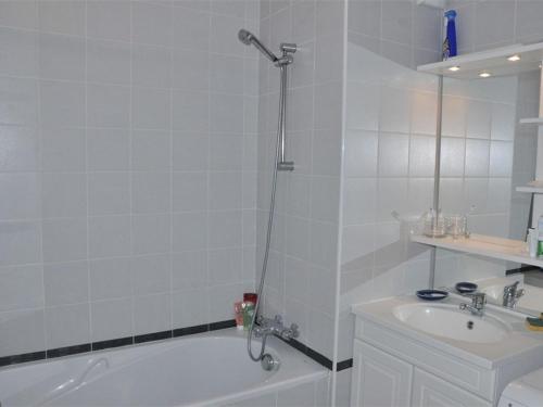 une salle de bain blanche avec une baignoire et un lavabo dans l'établissement Appartement 2 chambres vue mer à Trégastel avec parking - FR-1-368-186, à Trégastel