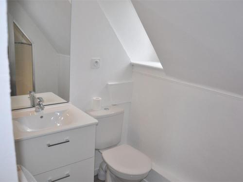 une salle de bain blanche avec des toilettes et un lavabo dans l'établissement Appartement rénové avec vue mer, proche plage, parking privé - FR-1-368-162, à Perros-Guirec