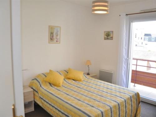 ペロス・ギレックにあるAppartement Perros-Guirec, 3 pièces, 4 personnes - FR-1-368-114のベッドルーム1室(黄色いシーツ付きのベッド1台、窓付)