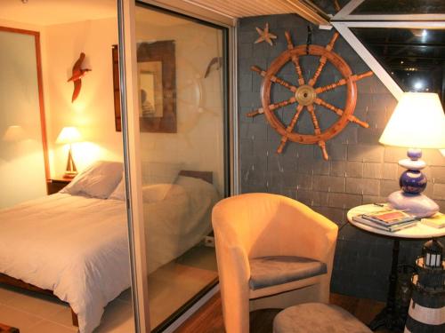 - une chambre avec un lit et une roue sur le mur dans l'établissement Appartement rénové 3* avec vue mer, à 50m plage, Perros-Guirec - FR-1-368-208, à Perros-Guirec