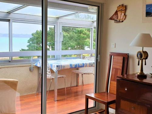 une salle à manger avec une table et un balcon dans l'établissement Appartement rénové 3* avec vue mer, à 50m plage, Perros-Guirec - FR-1-368-208, à Perros-Guirec
