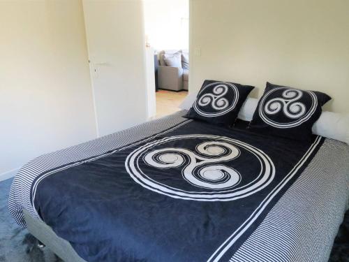 - un lit avec des oreillers en noir et blanc dans l'établissement Appartement Trébeurden, 3 pièces, 4 personnes - FR-1-368-212, à Trébeurden