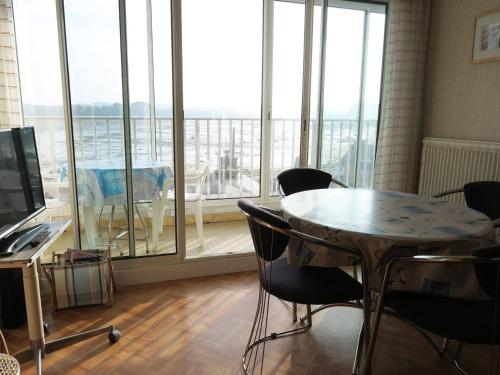 une pièce avec une table et des chaises et une grande fenêtre dans l'établissement Appartement 4 pers au centre de Trégastel, proche plages et commerces - FR-1-368-220, à Trégastel
