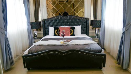 a bedroom with a large bed with a black headboard at 5BD Luxury Pool Villa Pattaya - Exquisite Pool Villa C in Pattaya South