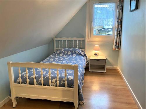 ein Kinderschlafzimmer mit einem Kinderbett und einem Fenster in der Unterkunft Maison à Perros-Guirec avec WIFI, proche centre-ville et plage, cour fermée, parking privé - FR-1-368-324 in Perros-Guirec