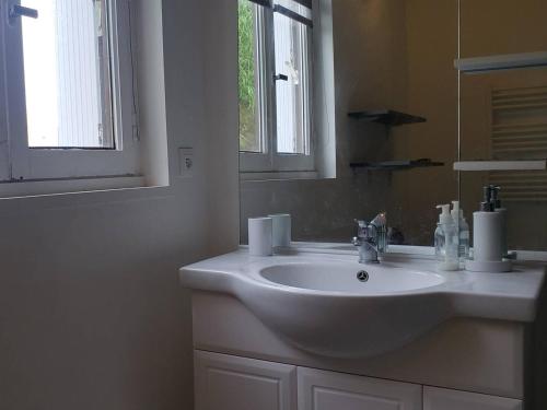 une salle de bain avec un lavabo blanc et un miroir dans l'établissement Appartement avec balcon, plage de Trestraou, parking inclus - FR-1-368-334, à Perros-Guirec