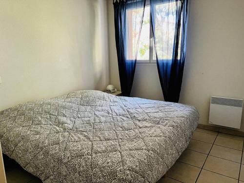 1 dormitorio con 1 cama y una ventana con cortinas azules en Appartement Cambo-les-Bains, 2 pièces, 2 personnes - FR-1-495-107, en Cambo-les-Bains