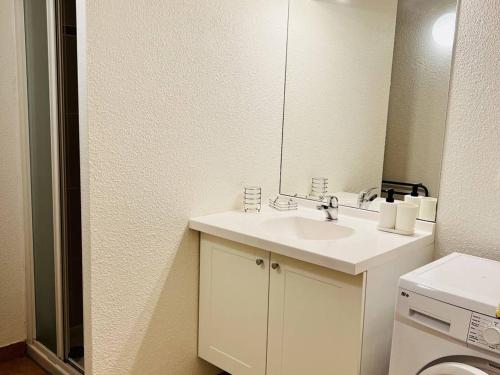 Baño blanco con lavabo y espejo en Appartement Cambo-les-Bains, 2 pièces, 2 personnes - FR-1-495-107, en Cambo-les-Bains