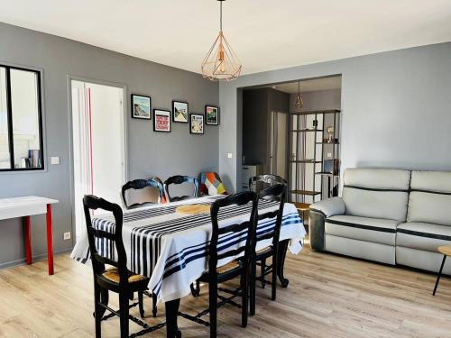 - une salle à manger avec une table, des chaises et un canapé dans l'établissement Appartement T2 Confortable avec Véranda et Parking - Proche Centre - Cambo-les-Bains - FR-1-495-108, à Cambo-les-Bains