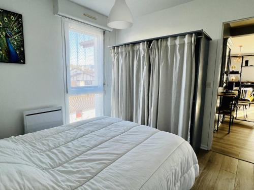 une chambre avec un lit et une grande fenêtre dans l'établissement Appartement T2 Confortable avec Véranda et Parking - Proche Centre - Cambo-les-Bains - FR-1-495-108, à Cambo-les-Bains