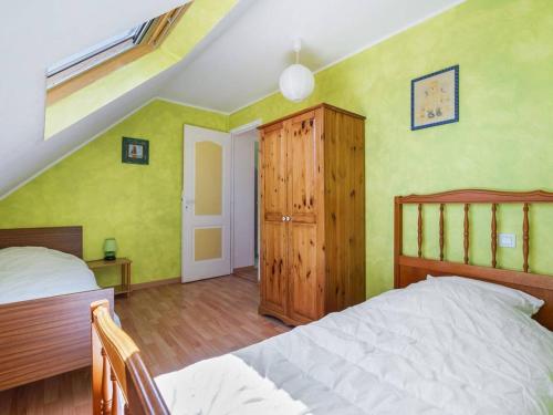 une chambre avec un lit et une armoire en bois dans l'établissement Maison 3* à l'Ile Grande, 200m plages, 6 pers, WIFI, parking, BBQ, proche GR34 - FR-1-368-187, à Pleumeur-Bodou