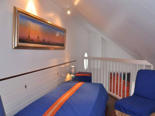 une chambre avec un lit et une chaise bleue dans l'établissement Maison à 100m de la mer avec WiFi, parking privé et jardin, au cœur de Trégastel - FR-1-368-210, à Trégastel