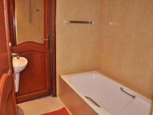 une salle de bain avec une baignoire et un lavabo dans l'établissement Maison à 100m de la mer avec WiFi, parking privé et jardin, au cœur de Trégastel - FR-1-368-210, à Trégastel