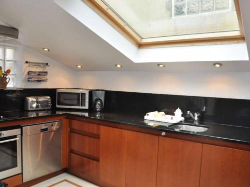 - une cuisine avec un plan de travail noir et un évier dans l'établissement Maison à 100m de la mer avec WiFi, parking privé et jardin, au cœur de Trégastel - FR-1-368-210, à Trégastel