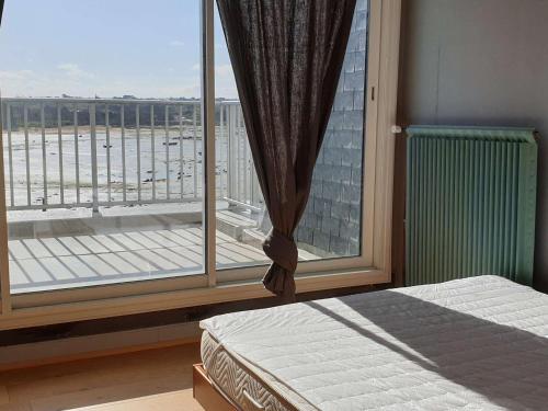 une chambre avec un lit et une grande fenêtre dans l'établissement Appartement duplex avec terrasse, vue mer, plages à 100m, Trégastel - FR-1-368-224, à Trégastel