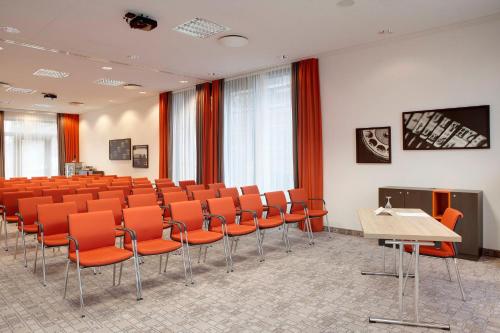 a conference room with orange chairs and a table at Holiday Inn Berlin City East Side by IHG in Berlin