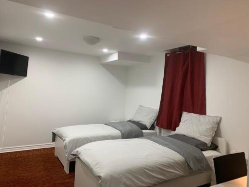 a room with two beds and a red curtain at Guest House Room No 03 in Mississauga