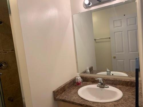 uma casa de banho com um lavatório e um espelho grande em Guest House Room No 03 em Mississauga