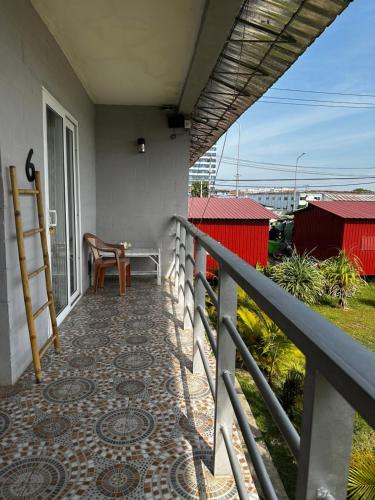 a balcony of a house with a table and a chair at Ginger Sihanoukville in Sihanoukville