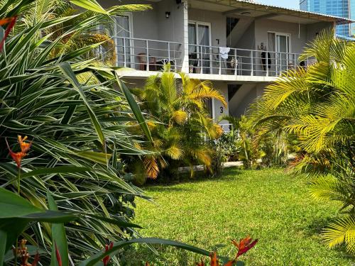 a balcony of a house with palm trees and a yard at Ginger Sihanoukville in Sihanoukville