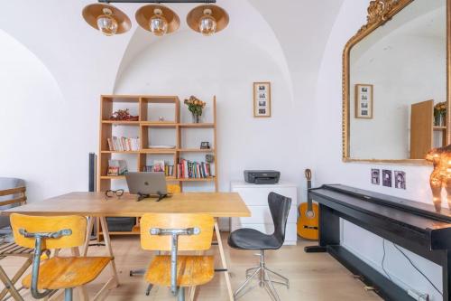 une salle à manger avec une table, des chaises et un miroir dans l'établissement Grand duplex Montmartre, à Paris