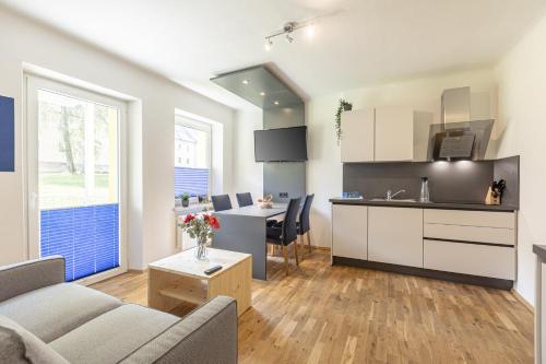 uma cozinha e sala de estar com um sofá e uma mesa em Erzberg Alpin Resort by ALPS RESORTS em Eisenerz