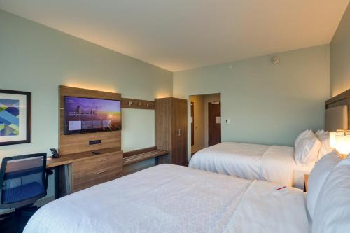 a hotel room with two beds and a flat screen tv at Holiday Inn Express & Suites - Charlotte - South End by IHG in Charlotte
