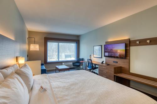 a hotel room with a bed and a flat screen tv at Holiday Inn Express & Suites - Charlotte - South End by IHG in Charlotte