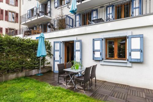a patio with a table and chairs and an umbrella at Vallorcine Apartments - Happy Rentals in Vallorcine