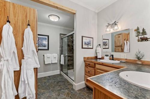 een badkamer met een bad, een wastafel en een douche bij Glacier Paradise in Hungry Horse