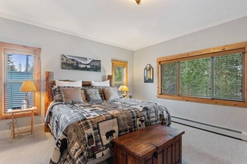 Schlafzimmer mit einem Bett, einem Tisch und einem Fenster in der Unterkunft Glacier Paradise in Hungry Horse