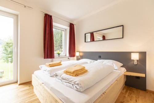 アイゼンエルツにあるErzberg Alpin Resort by ALPS RESORTSのベッドルーム1室(大きな白いベッド1台、タオル付)