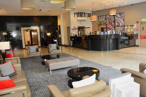 a lobby with couches and chairs and a bar at Abell Hotel in Kuching