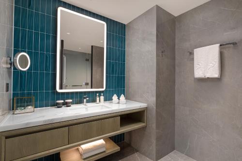a bathroom with a sink and a mirror at Xiamen International Seaside Hotel -Hotel corridor leads to the stone exhibition hall in Xiamen