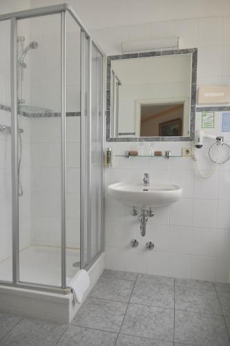 a bathroom with a shower and a sink at Jahrhunderthotel Leipzig in Leipzig