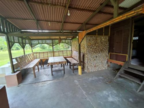 um pátio com bancos e uma mesa num edifício em Port Mancing Fishing Village em Kampong Ulu Kalong