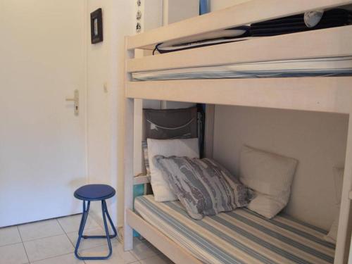 Cette chambre comprend un lit superposé avec un tabouret. dans l'établissement Appartement T2 cosy avec piscine, terrasse, parking sécurisé proche plage et commerces - Le Lavandou - FR-1-251-227, au Lavandou