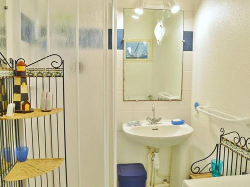 une salle de bain blanche avec un lavabo et un miroir dans l'établissement Appartement T2 cosy avec piscine, terrasse, parking sécurisé proche plage et commerces - Le Lavandou - FR-1-251-227, au Lavandou
