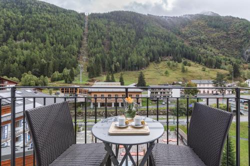 a table on a balcony with a view of a mountain at Vallorcine Apartments - Happy Rentals in Vallorcine