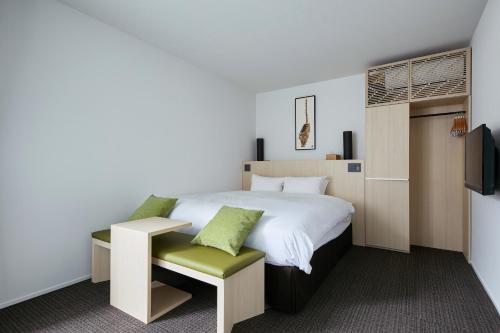 a hotel room with a bed and a television at HOTEL KYOTOLOGY in Kyoto
