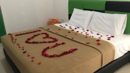a bed with a heart made out of rose petals at DLAYARAN VILLA GUEST HOUSE in Kuala Rompin