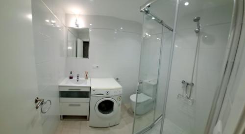 een witte badkamer met een wasmachine en een toilet bij la ventana al mar in Jávea