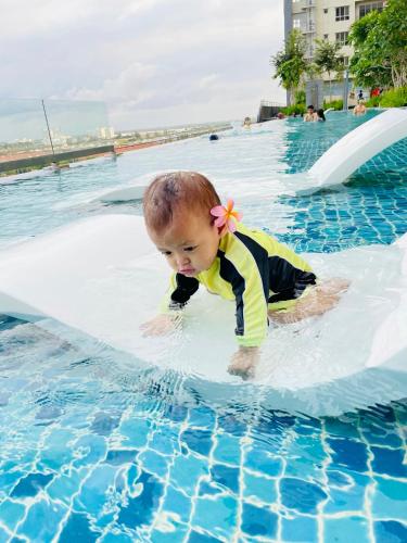 a baby is playing in a swimming pool at Wallaway2stay Gravit8 Klang 2Room in Klang